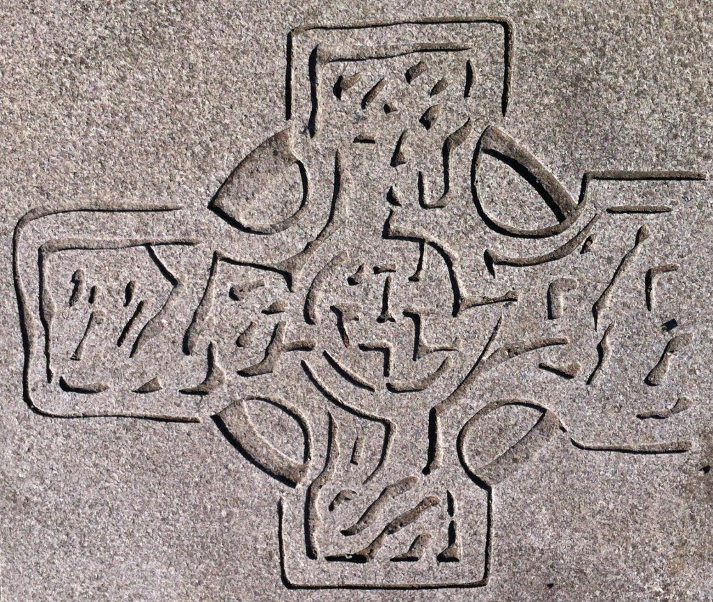 Photo of a stylised celtic cross carving in pavement.