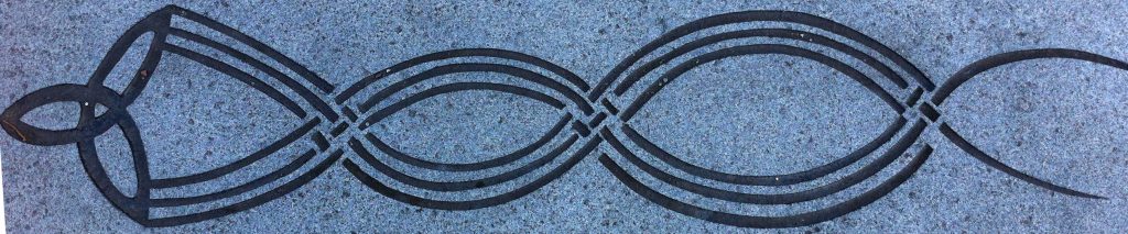 Celtic trinity symbol with tail  that streams behind it that intertwines to represent weaving (pavement carving in Govan). 